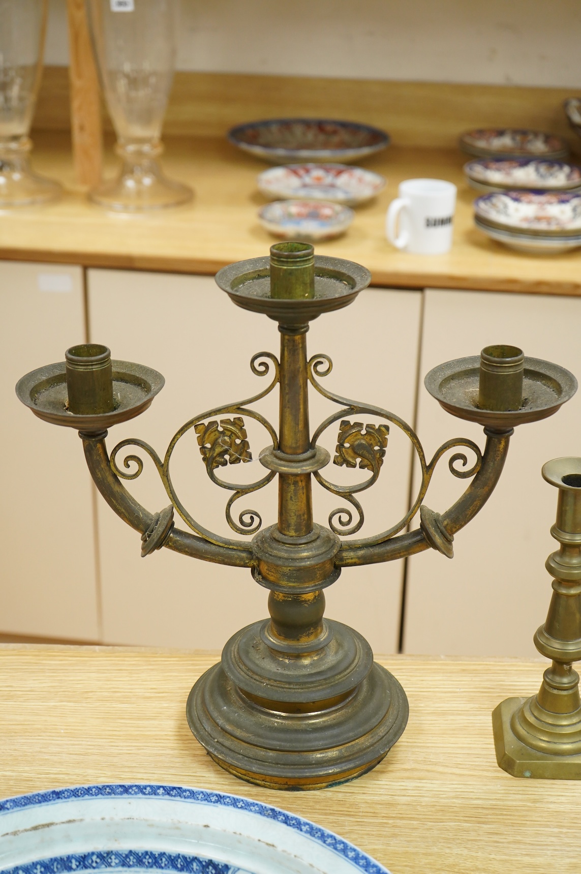 A pair of two brass branch, three light candelabra and two other brass candlesticks, largest 38cm high